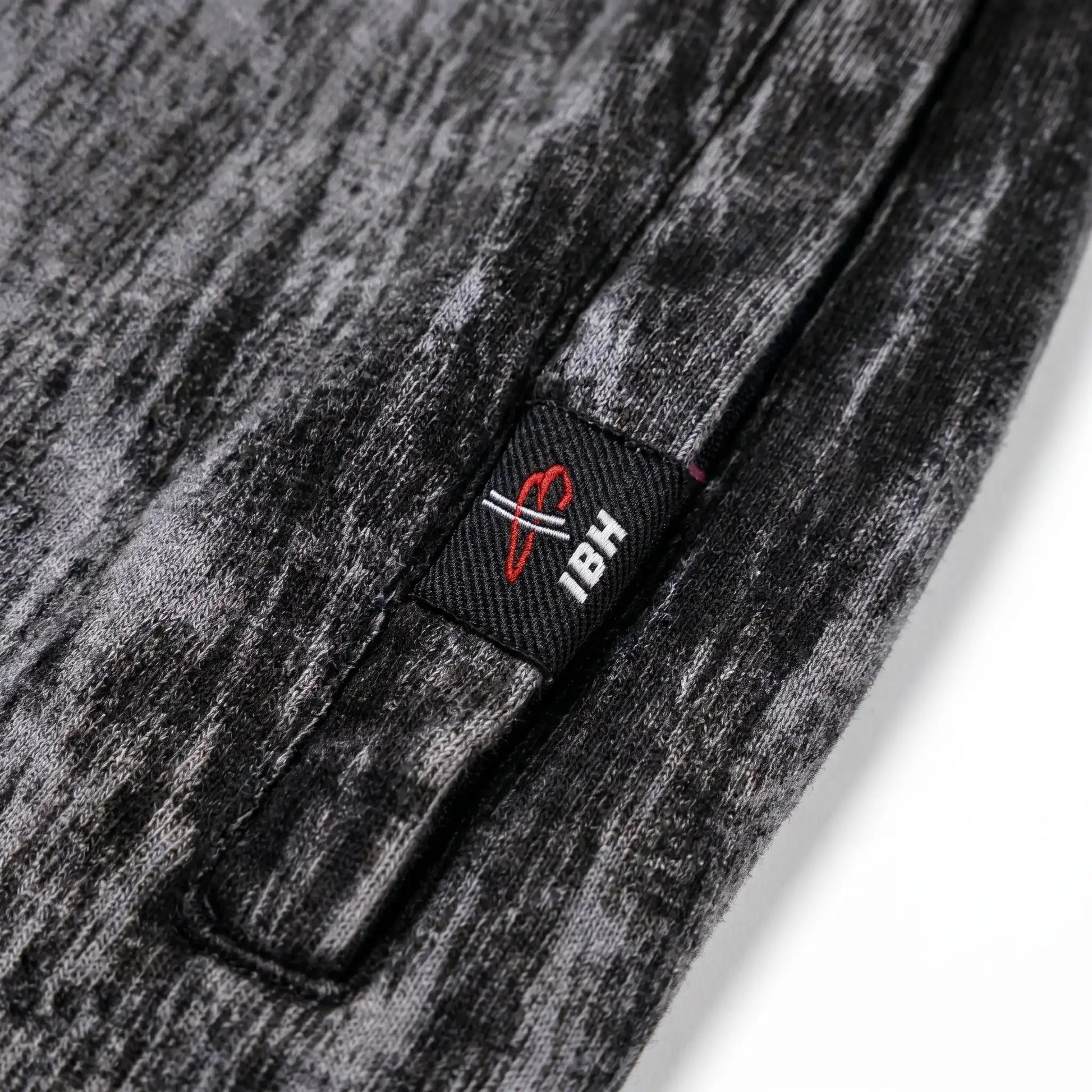 Close-up of a textured gray fabric with a brand logo tag.